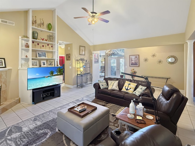 tiled living room with a tile fireplace, french doors, ceiling fan with notable chandelier, and high vaulted ceiling