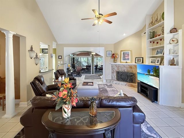 tiled living room with ceiling fan, a premium fireplace, high vaulted ceiling, and decorative columns