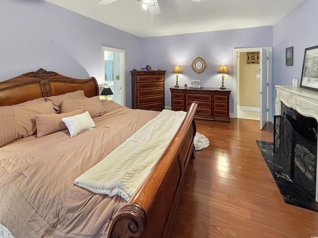 bedroom with ceiling fan, dark hardwood / wood-style flooring, and connected bathroom