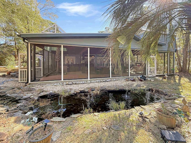 rear view of house featuring a sunroom