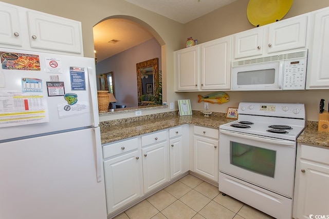 kitchen featuring light tile patterned floors, white appliances, white cabinetry, and dark stone counters