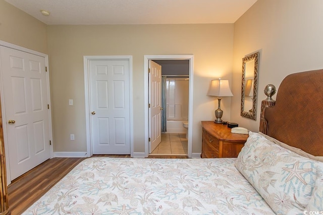 bedroom featuring ensuite bathroom and wood-type flooring