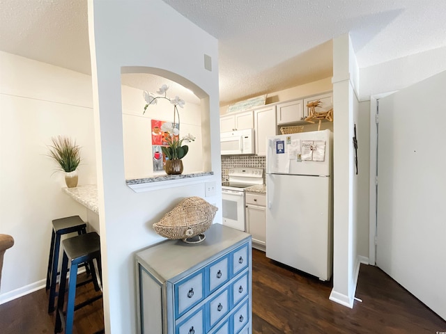 kitchen featuring white appliances, white cabinetry, blue cabinets, and backsplash