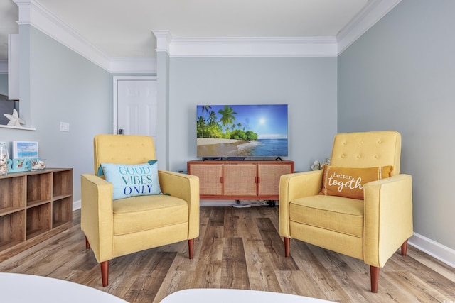 living area featuring wood-type flooring and crown molding