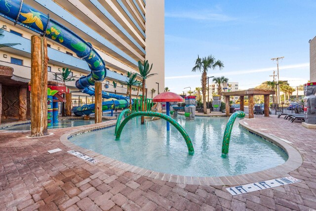 view of swimming pool featuring a patio and a water slide