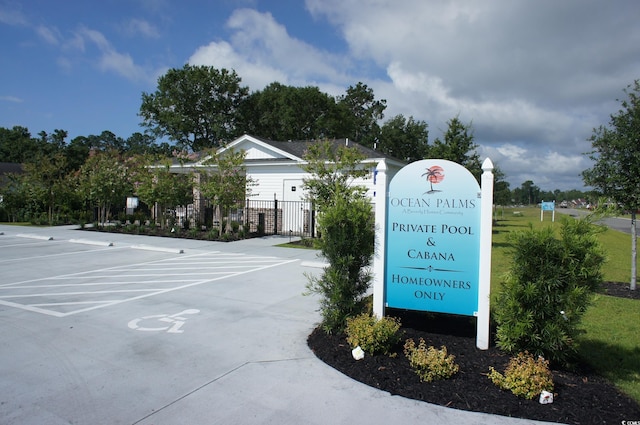 exterior space with a gate, uncovered parking, and fence