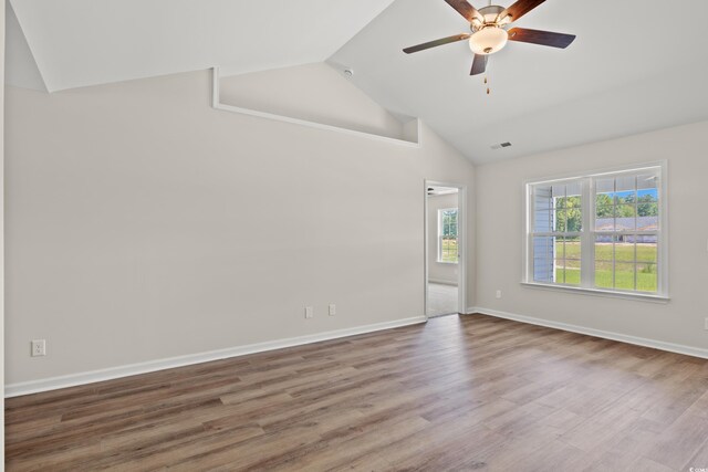 unfurnished room with hardwood / wood-style flooring, ceiling fan, and vaulted ceiling