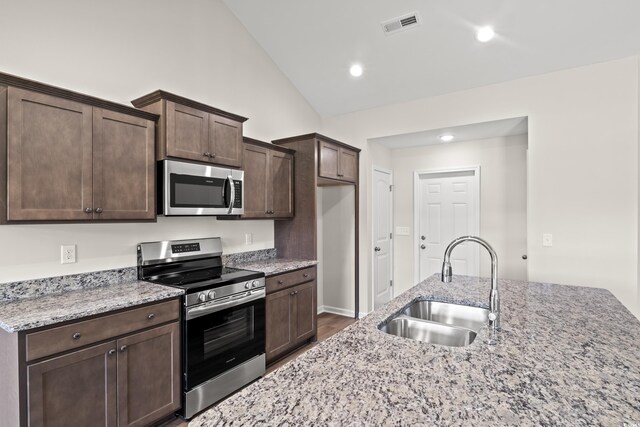399 Lifestyle Ct, Surfside Beach, SC 29575 - kitchen featuring light stone counters, dark brown cabinets, stainless steel appliances, sink, and hardwood / wood-style flooring