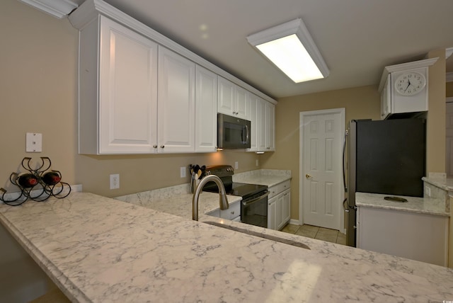 kitchen featuring kitchen peninsula, light stone countertops, black appliances, white cabinetry, and light tile patterned flooring