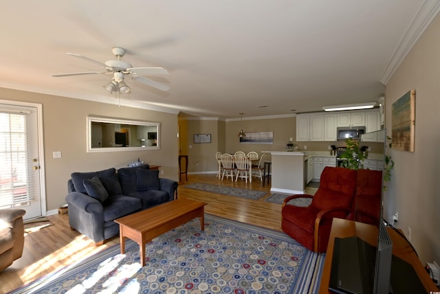 living room featuring ceiling fan, light hardwood / wood-style floors, and ornamental molding