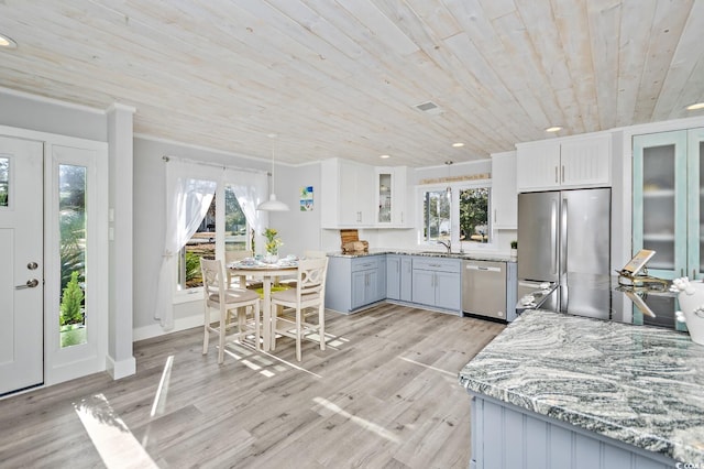 kitchen featuring a wealth of natural light, stainless steel appliances, wooden ceiling, pendant lighting, and white cabinets