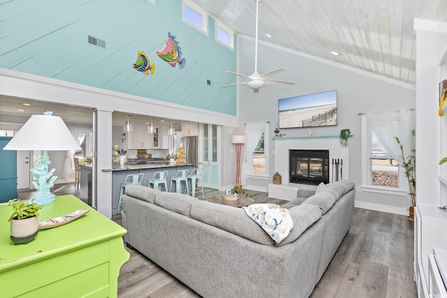 living room featuring a fireplace, high vaulted ceiling, wooden ceiling, and light wood-type flooring