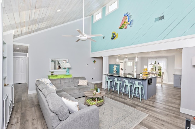 living room with ceiling fan, high vaulted ceiling, and light wood-type flooring