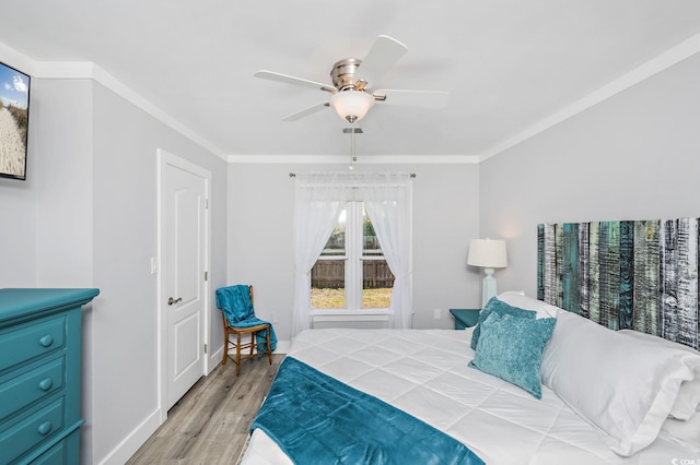 bedroom with ceiling fan, crown molding, and light hardwood / wood-style flooring