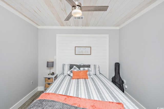 bedroom featuring dark hardwood / wood-style flooring, ceiling fan, crown molding, and wood ceiling