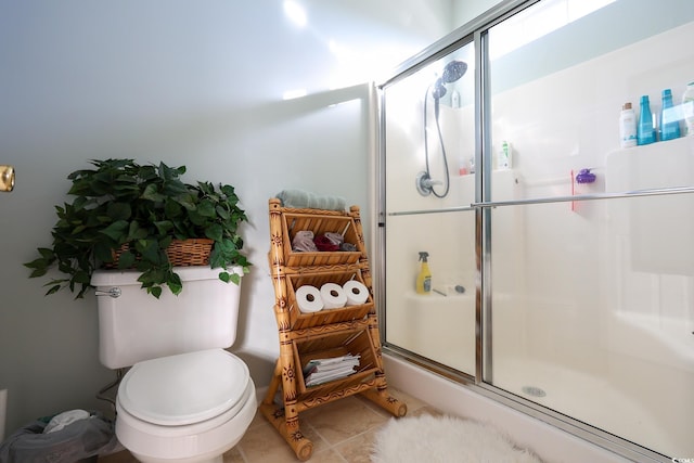 bathroom featuring tile patterned floors, toilet, and walk in shower