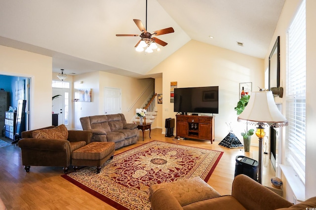 living room with light hardwood / wood-style floors, high vaulted ceiling, and ceiling fan