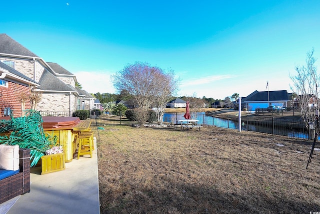 view of yard with a patio, a water view, and a bar