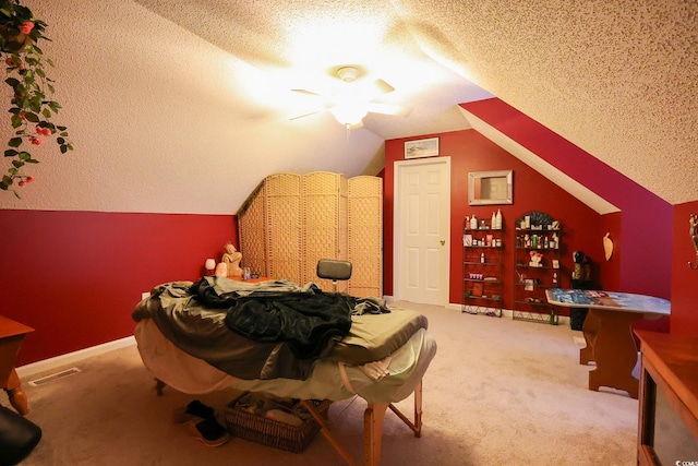 bedroom with a textured ceiling, vaulted ceiling, and carpet