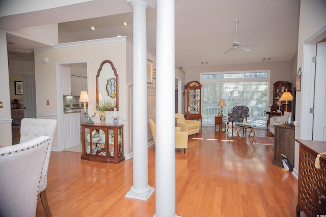 corridor with light hardwood / wood-style flooring and decorative columns