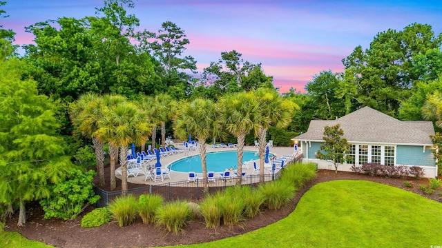 pool at dusk featuring a patio area