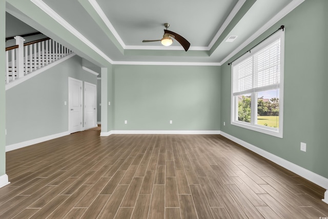1405 Osprey Pointe Ln, North Myrtle Beach, SC 29582 - spare room featuring a tray ceiling, a ceiling fan, dark wood-style flooring, crown molding, and stairway