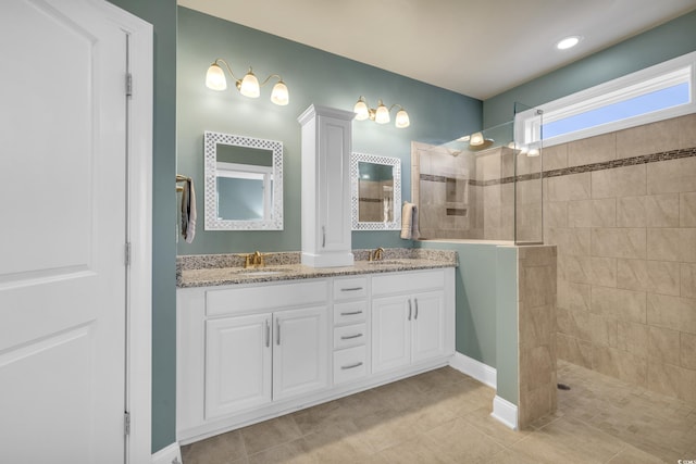 bathroom featuring tile patterned floors, vanity, and tiled shower