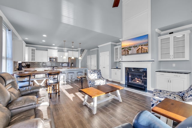 1405 Osprey Pointe Ln, North Myrtle Beach, SC 29582 - living room with crown molding, dark wood-style floors, recessed lighting, a fireplace with flush hearth, and a high ceiling