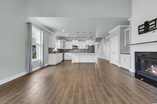 1405 Osprey Pointe Ln, North Myrtle Beach, SC 29582 - unfurnished living room featuring ornamental molding, dark wood-style floors, recessed lighting, and a glass covered fireplace