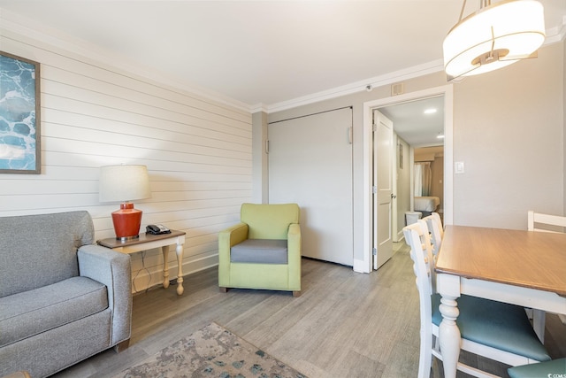 living area with wood-type flooring and crown molding