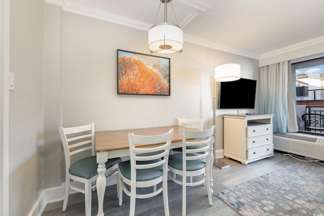 dining area with wood finished floors, baseboards, and ornamental molding