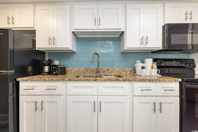 kitchen featuring white cabinetry, black appliances, decorative backsplash, and a sink