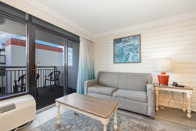 living room featuring hardwood / wood-style flooring, an AC wall unit, ornamental molding, and wooden walls