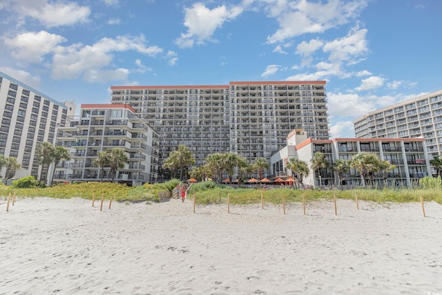 view of building exterior featuring a water view and a view of the beach