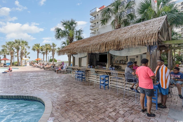 view of patio featuring a community pool and outdoor dry bar