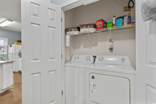 laundry room featuring washer and clothes dryer and hardwood / wood-style floors