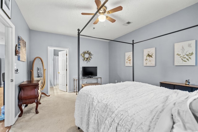 bedroom featuring ceiling fan, light carpet, and a textured ceiling