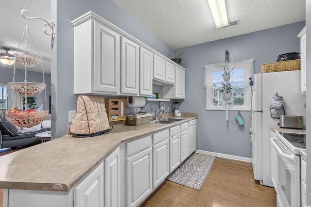 kitchen featuring white appliances, white cabinets, sink, plenty of natural light, and light hardwood / wood-style floors