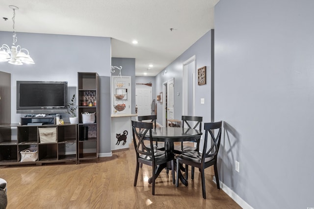 dining room featuring a chandelier, a textured ceiling, and hardwood / wood-style flooring