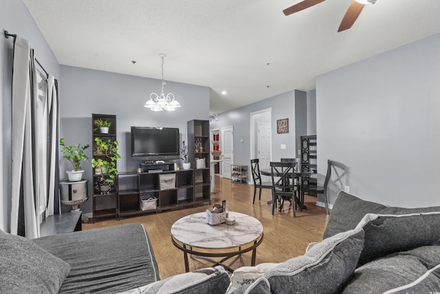 living room featuring hardwood / wood-style floors and ceiling fan with notable chandelier