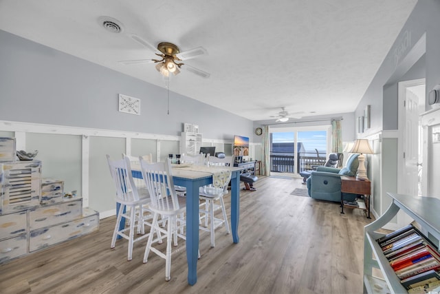 dining room featuring ceiling fan, a textured ceiling, and light hardwood / wood-style flooring