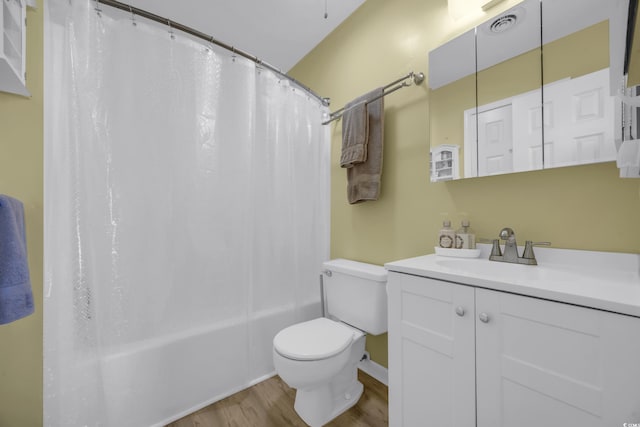 full bathroom with hardwood / wood-style floors, vanity, shower / bath combination with curtain, and toilet