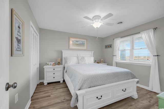 bedroom with ceiling fan, a closet, and light hardwood / wood-style floors