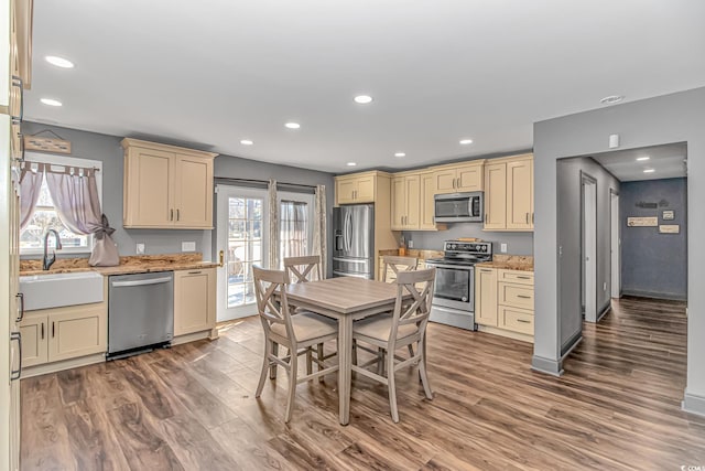 kitchen featuring hardwood / wood-style flooring, sink, cream cabinetry, and appliances with stainless steel finishes