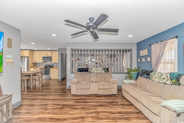 living room featuring wood-type flooring and ceiling fan