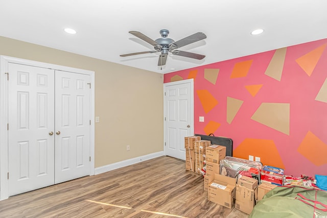 bedroom featuring hardwood / wood-style floors, ceiling fan, and a closet