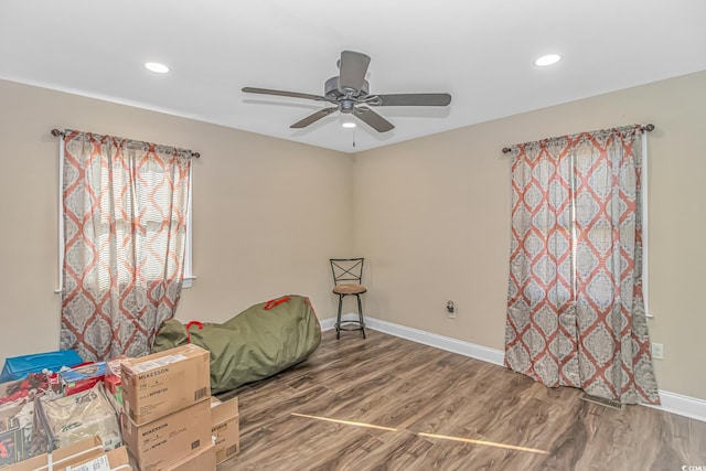 living area with hardwood / wood-style floors and ceiling fan