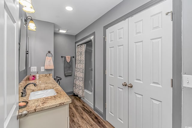 bathroom featuring hardwood / wood-style floors, vanity, and shower / tub combo