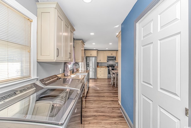 kitchen with dark hardwood / wood-style floors, light brown cabinetry, sink, and appliances with stainless steel finishes