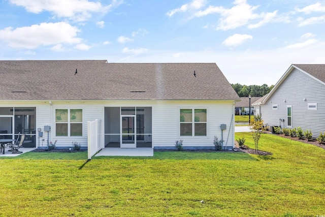 rear view of house featuring a sunroom, a patio area, and a lawn